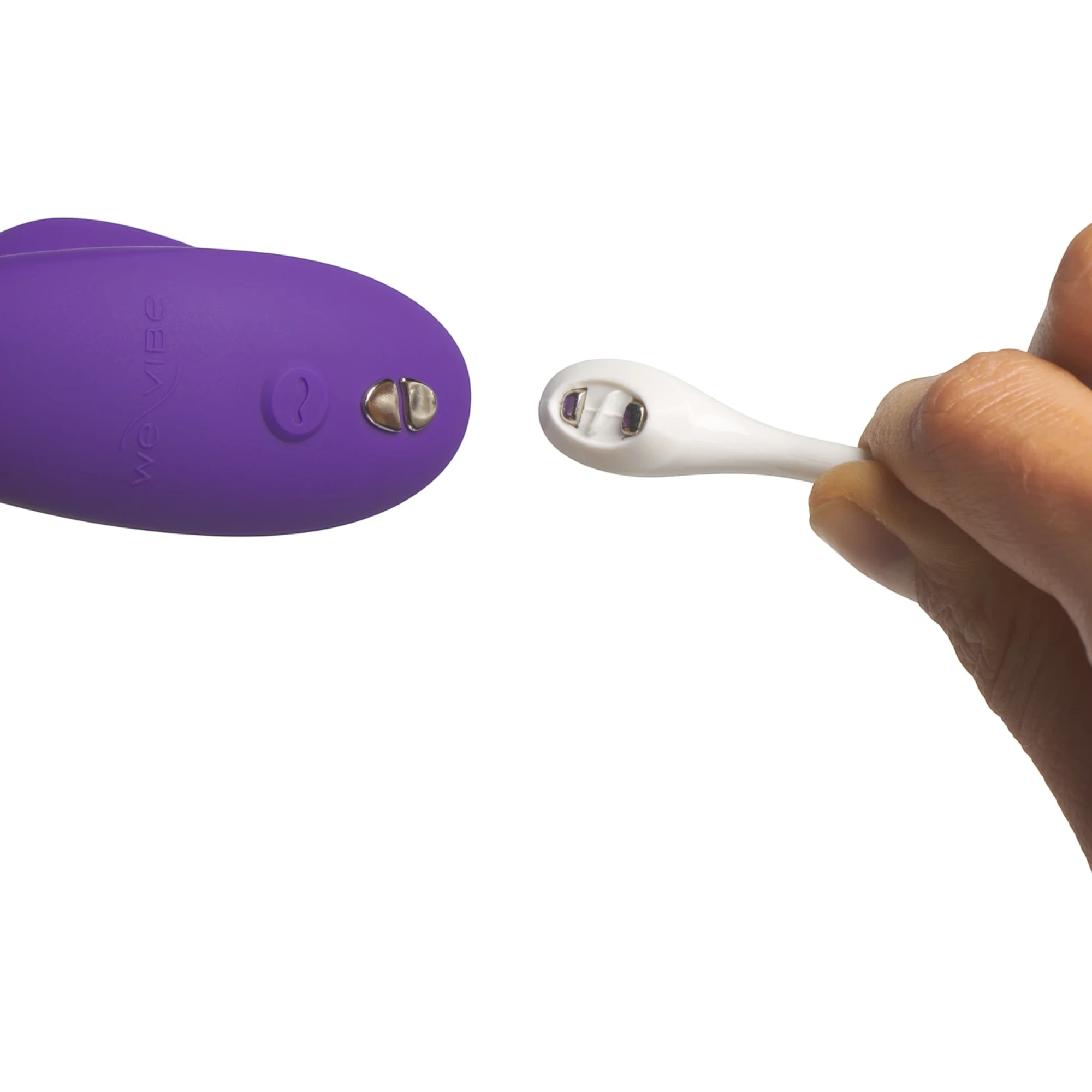 We-Vibe Sync 2 purple couples vibrator with white wireless remote held in hands showing control buttons against white background