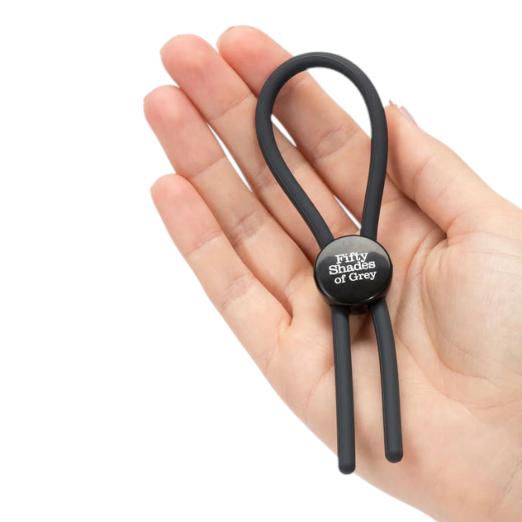 Fifty Shades of Grey Again and Again black adjustable cock ring held close-up in hand displaying metal connector ring with product branding detail, dual silicone strands, loop handle, and compact size against white background