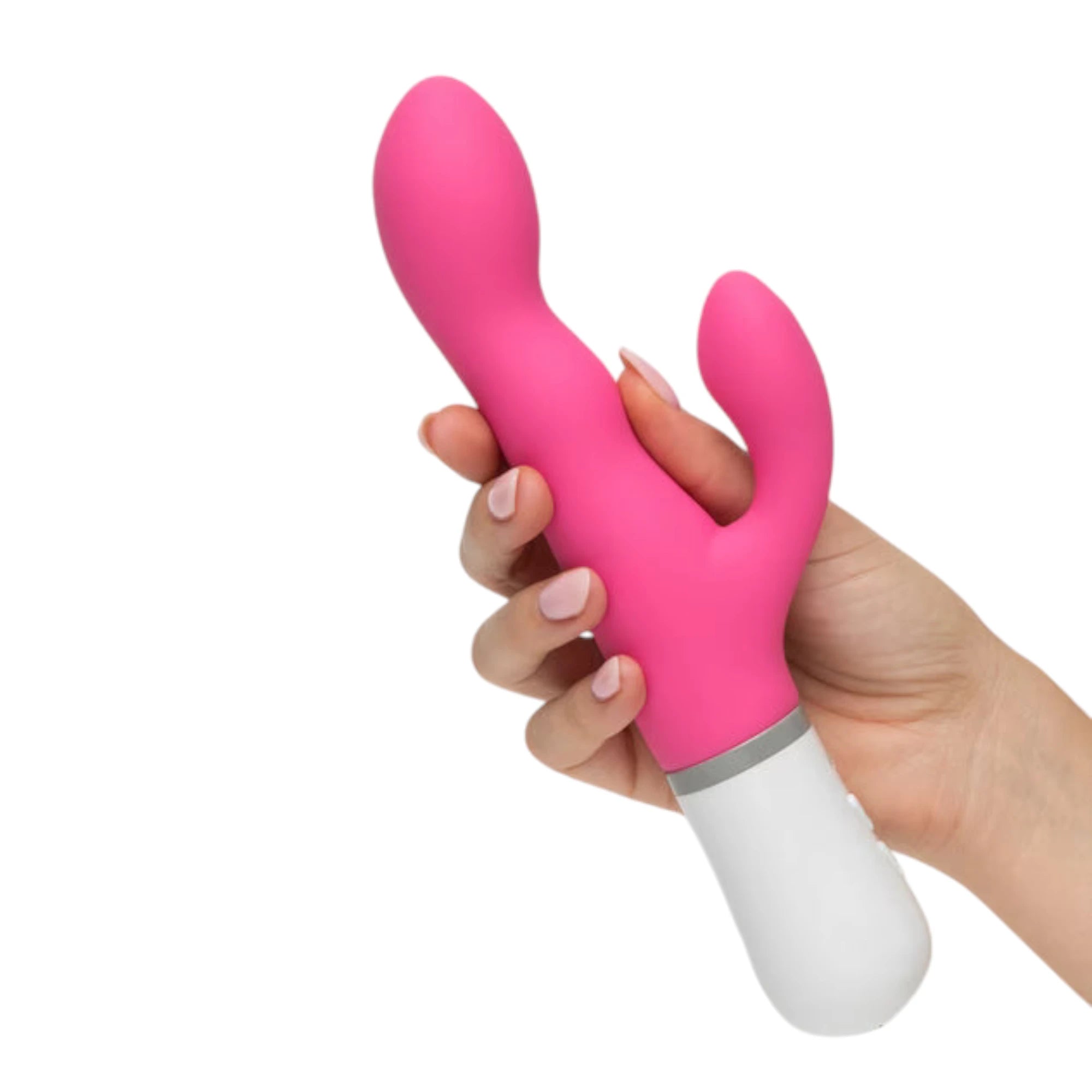 Lovense Nora hot pink and white rotating rabbit vibrator gripped in hand displaying curved dual-stimulation arms, rounded clitoral bulb, internal rotating arm, white handle with grey accent band, and ergonomic grip against white background
