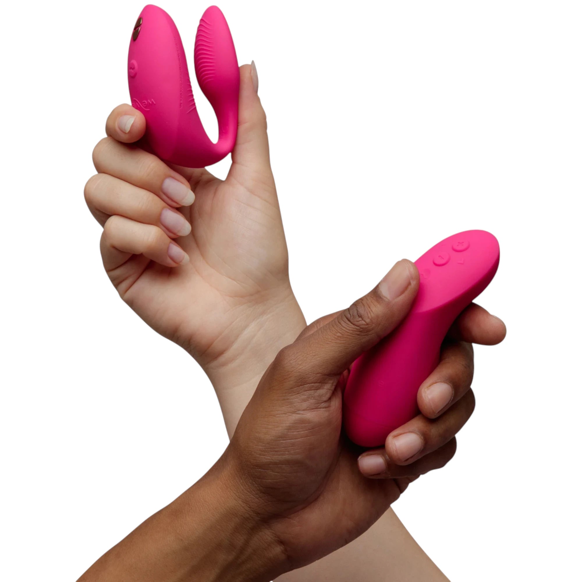 We-Vibe Chorus Pro couple vibrator in hot pink held in hands displaying dual curved bodies with textured ridges, external stimulator arm, control buttons, and smooth silicone finish against white background