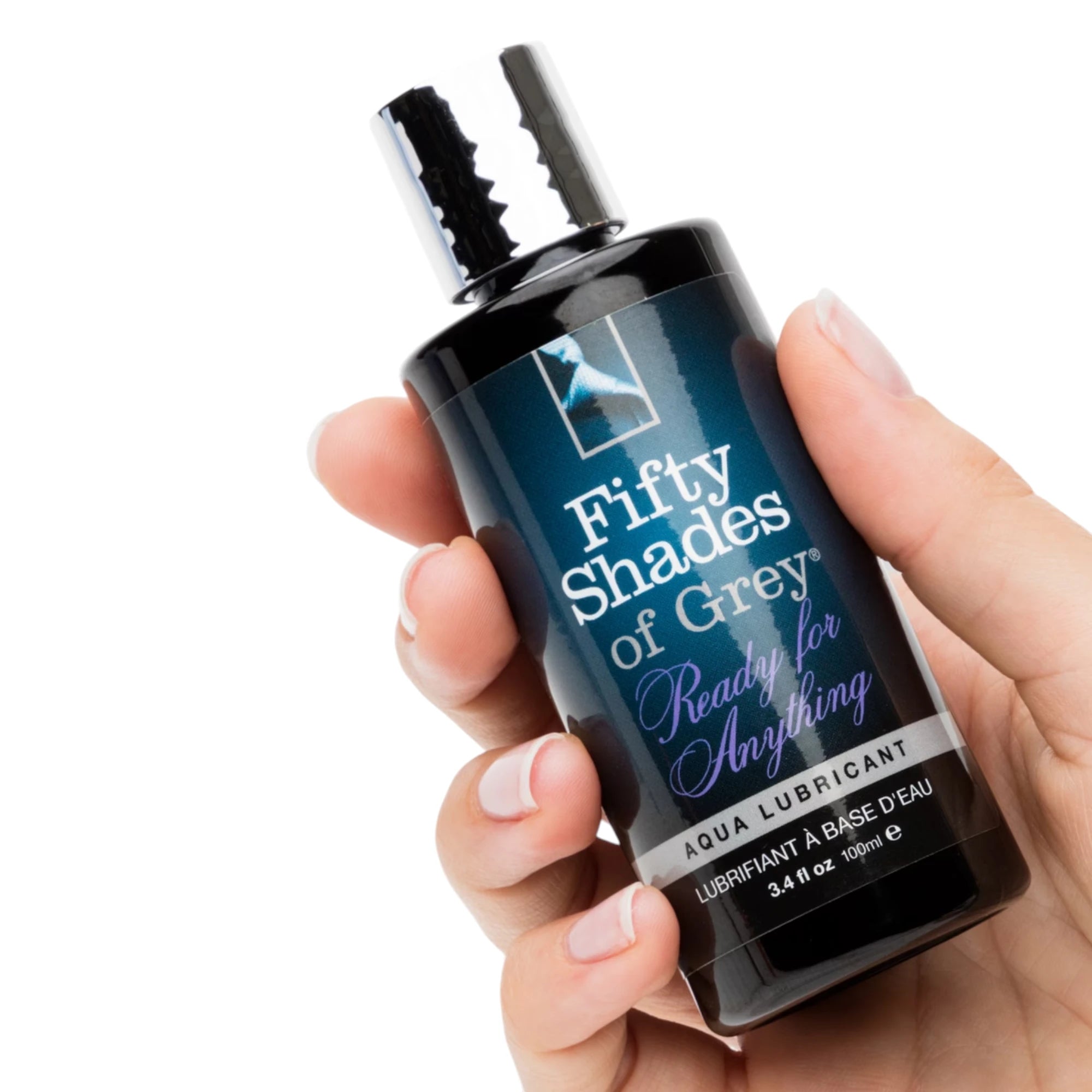 Fifty Shades of Grey Ready for Anything aqua lubricant 100ml bottle held in hand displaying chrome flip-top cap, black liquid formula, Fifty Shades of Grey branding, 'Ready for Anything' label, and grey feather logo against white background