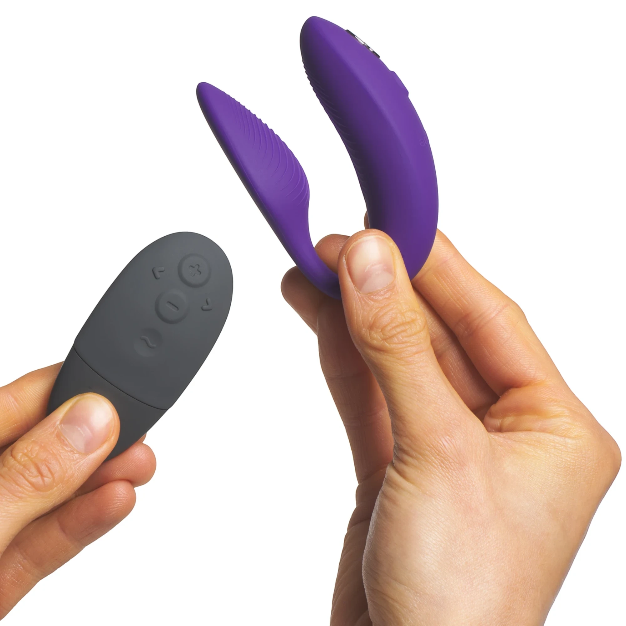 We-Vibe Sync 2 purple couples vibrator with black wireless remote held in hands against white background