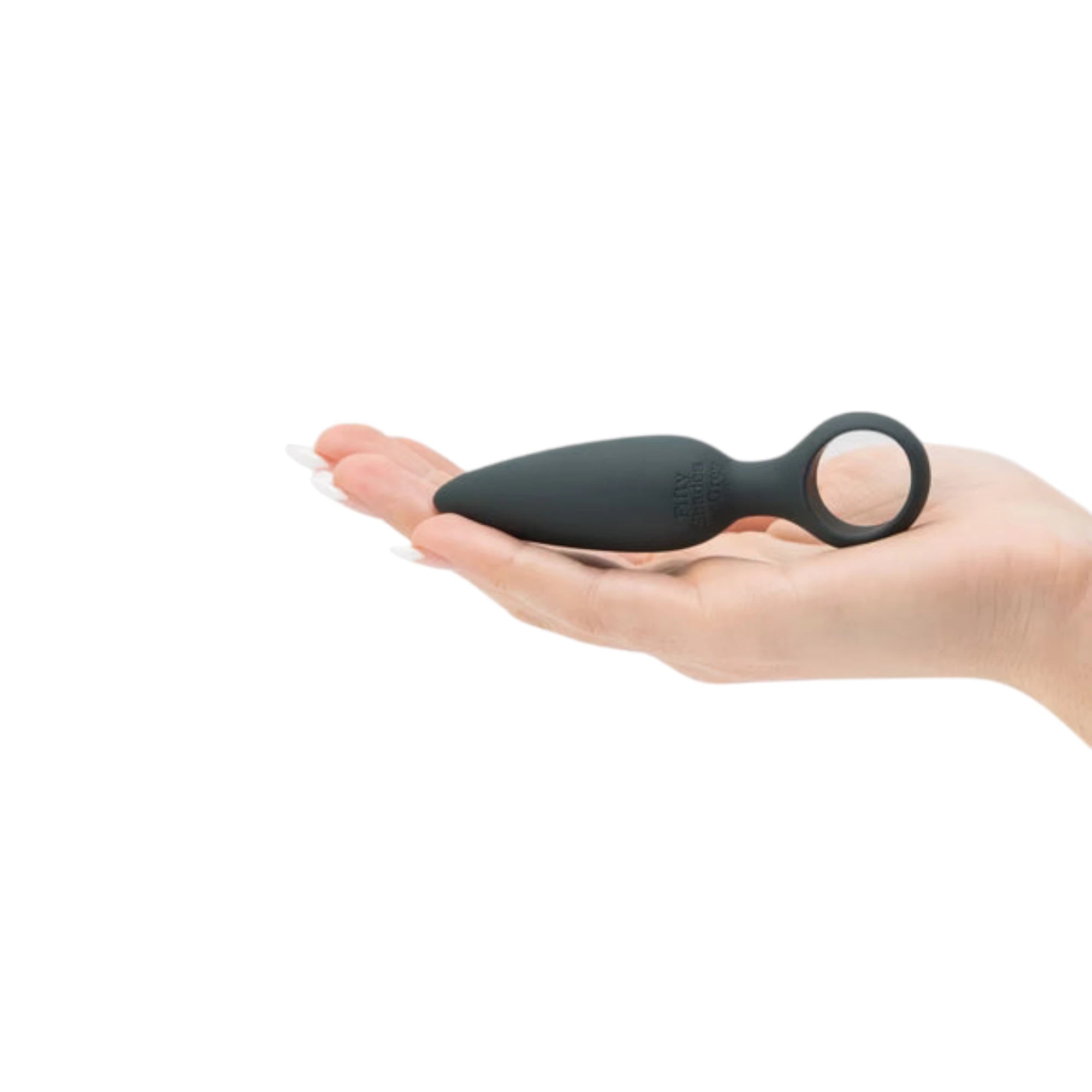 Fifty Shades of Grey Come Hither silicone anal plug in black held in open palm displaying tapered bulbous tip, finger loop base, Fifty Shades of Grey branding, and smooth silicone finish against white background