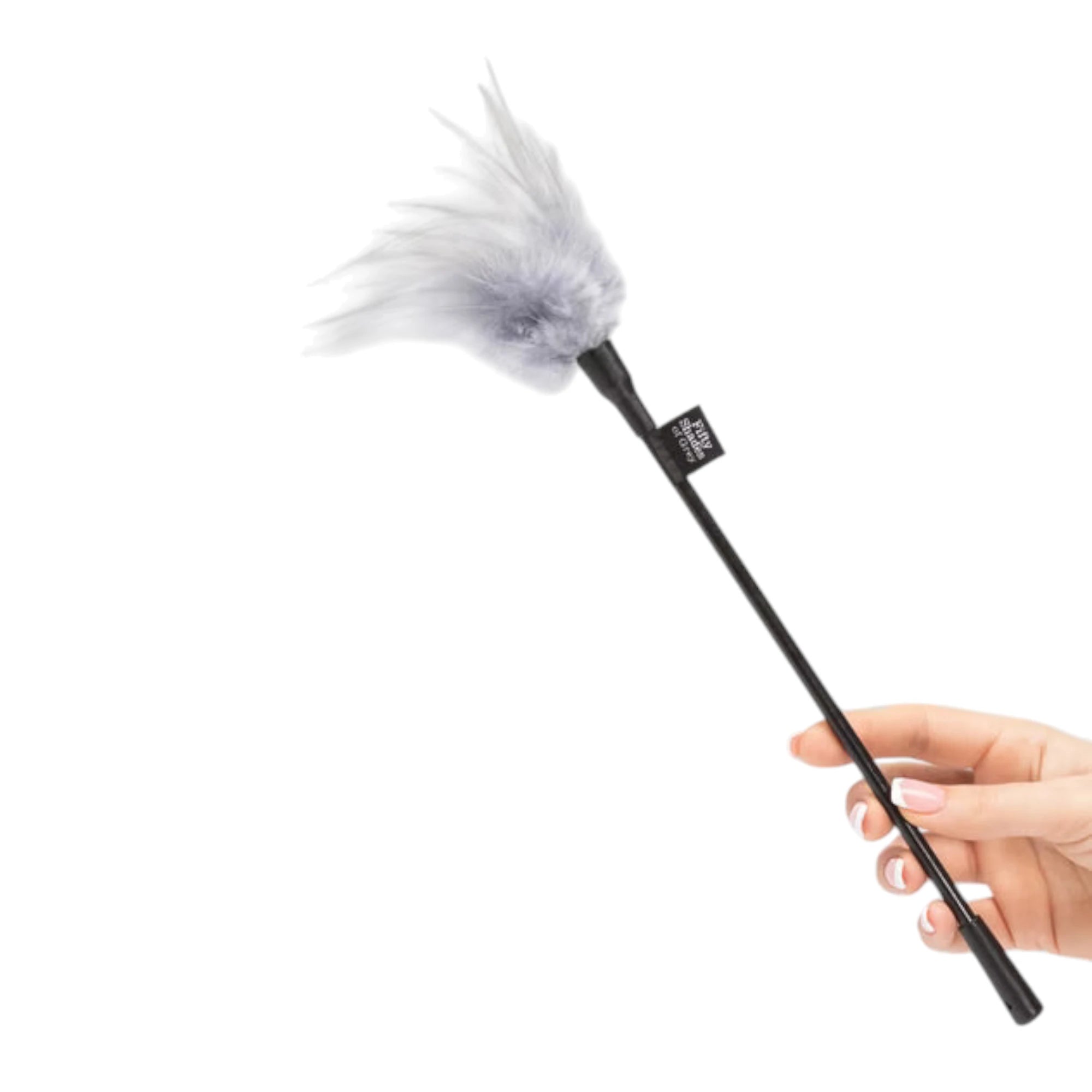 Fifty Shades of Grey Tease feather tickler held in hand displaying white feather plume, black metal handle with Fifty Shades of Grey branding label, and soft feather texture against white background