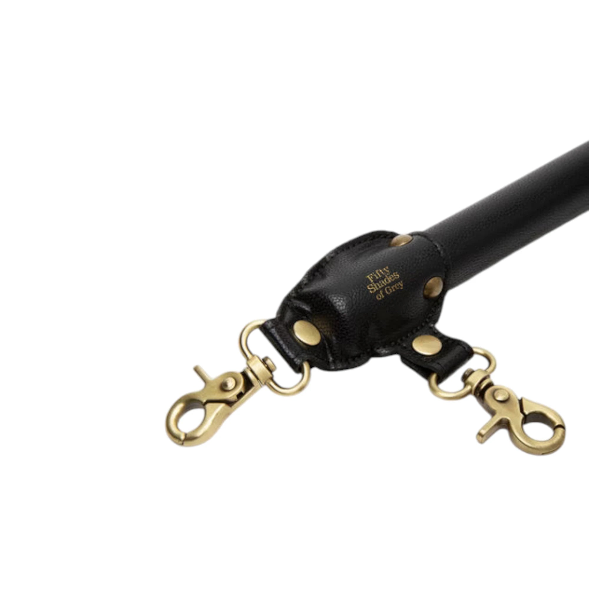 Fifty Shades of Grey Bound to You faux leather spreader bar shown close up displaying black faux leather end cap with gold 'Fifty Shades of Grey' branding, gold rivets, and two gold-toned swivel clips attached to D-rings against white background