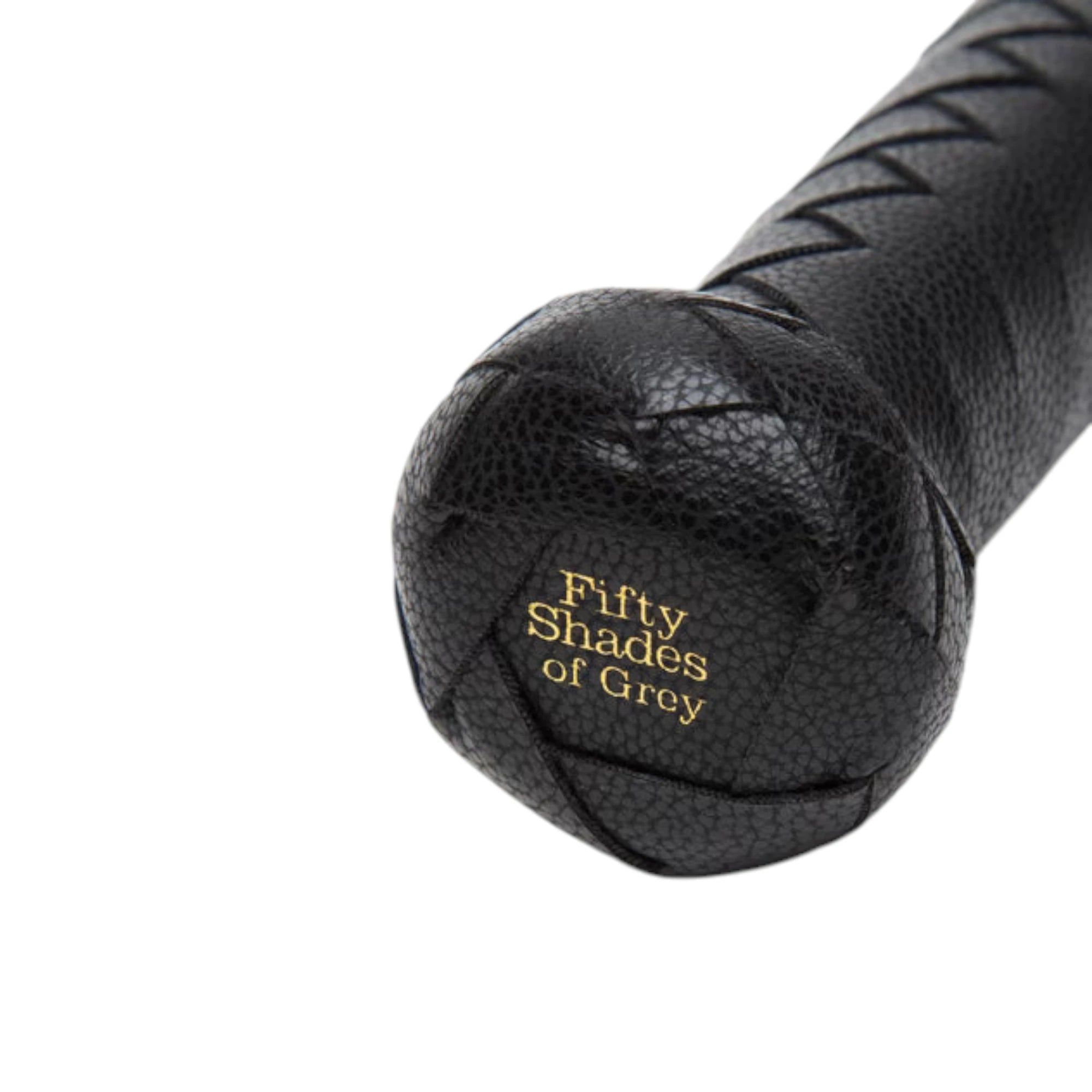 Fifty Shades of Grey Bound to You faux leather flogger in black shown close up displaying rounded pommel grip with gold Fifty Shades of Grey branding, textured faux leather surface, and braided handle against white background