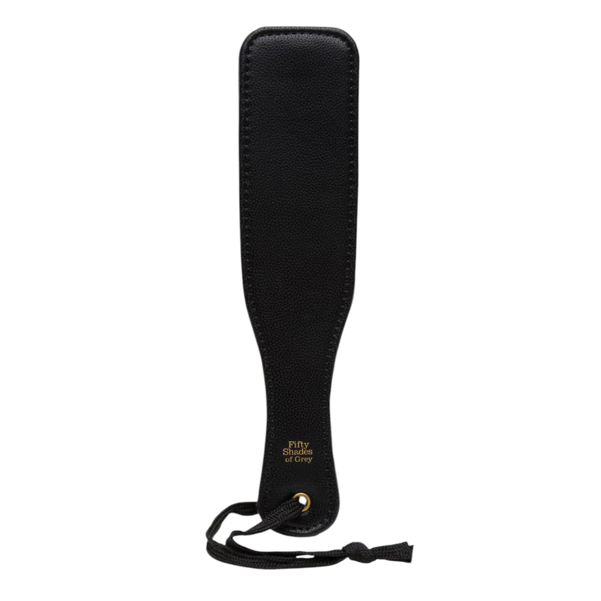 Fifty Shades of Grey Bound to You faux leather small spanking paddle in black shown from front displaying flat paddle head with textured surface, gold Fifty Shades of Grey branding, wrist strap, and smooth handle against white background