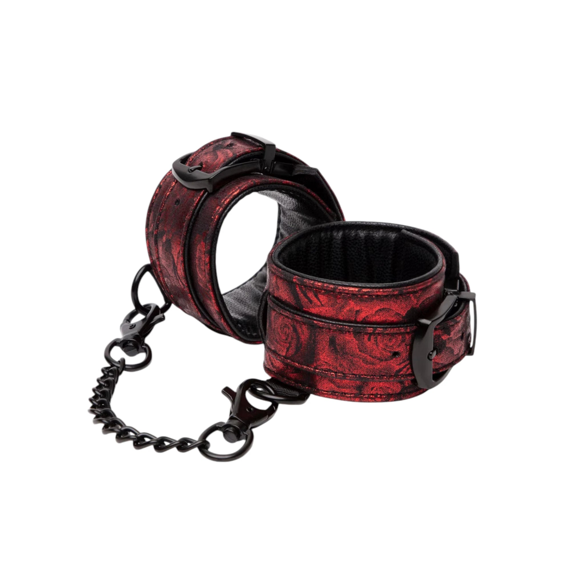Fifty Shades of Grey Sweet Anticipation reversible faux leather wrist cuffs in burgundy and black jacquard pattern shown from front displaying padded cuffs with black hardware, D-ring attachment points, and connecting chain against white background