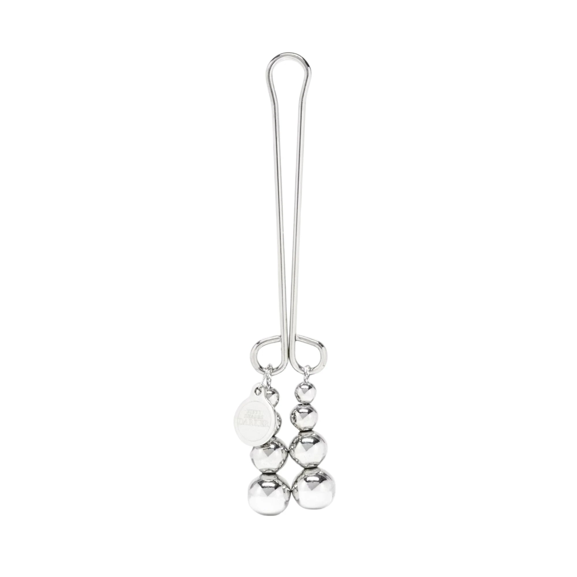 Fifty Shades Darker Just Sensation beaded clitoral clamp shown full length, featuring a silver metal clamp with a loop handle and two dangling strands of graduated metal beads with a small branded charm against a white background