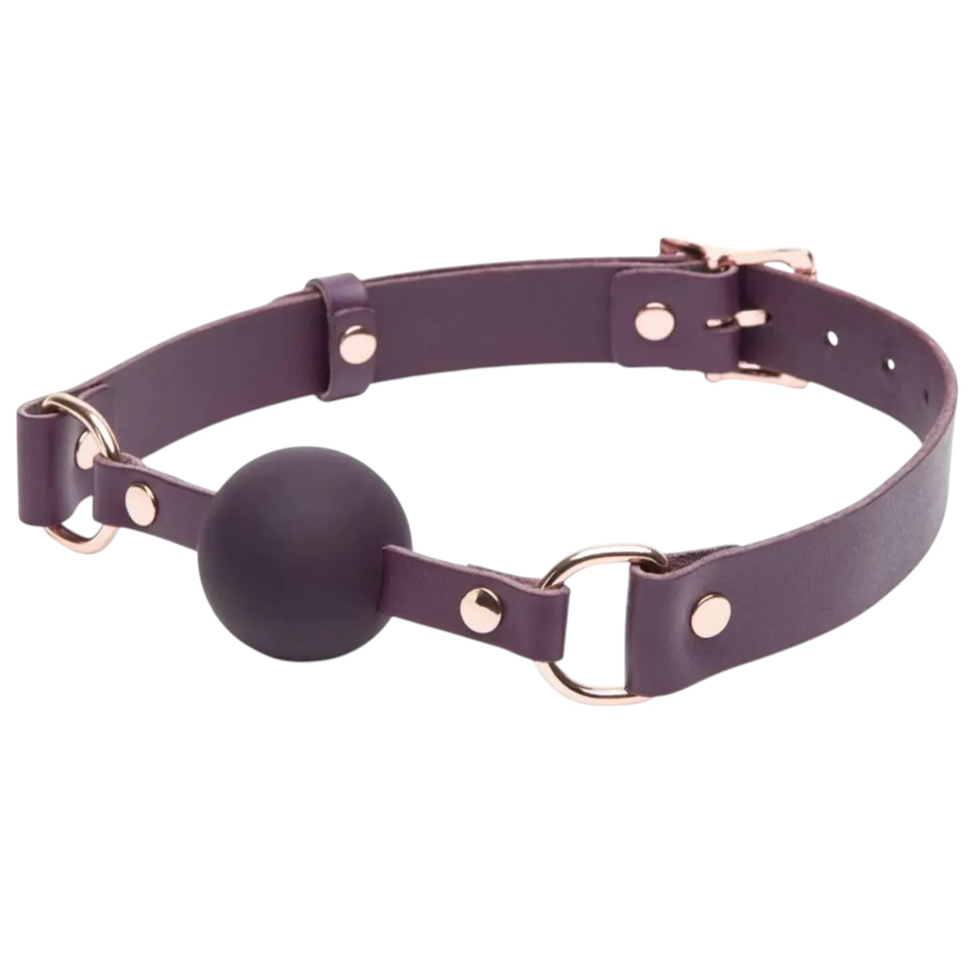 Fifty Shades Freed Cherished Collection leather ball gag shown at an angle, featuring a purple adjustable strap with metal rings and rivets, a rose-gold buckle, and a dark silicone ball at the centre against a white background.