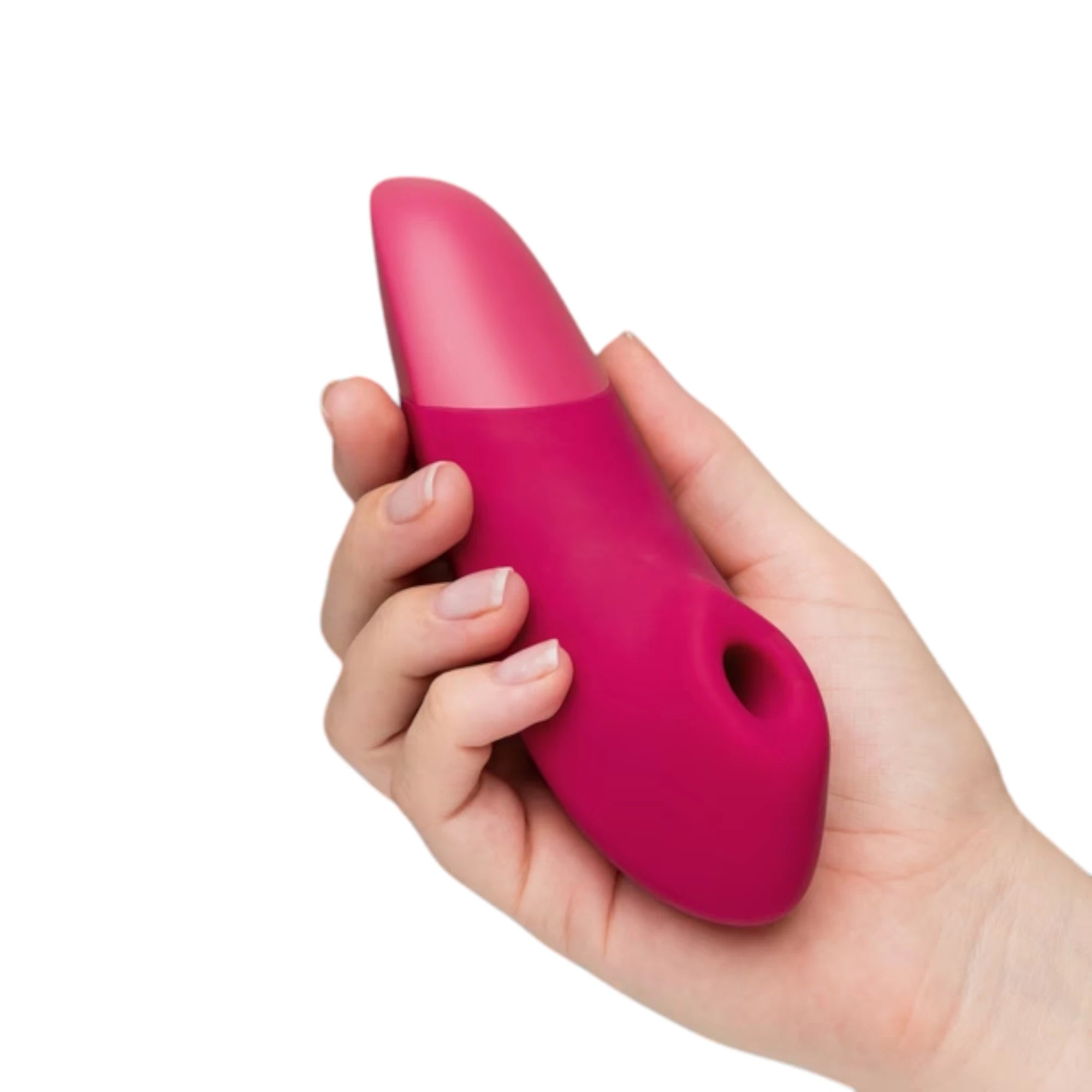 Womanizer Enhance pink Pleasure Air clitoral vibrator shown held in a hand for size reference, highlighting the smooth curved body, two-tone pink design and the Pleasure Air opening at the front against a white background
