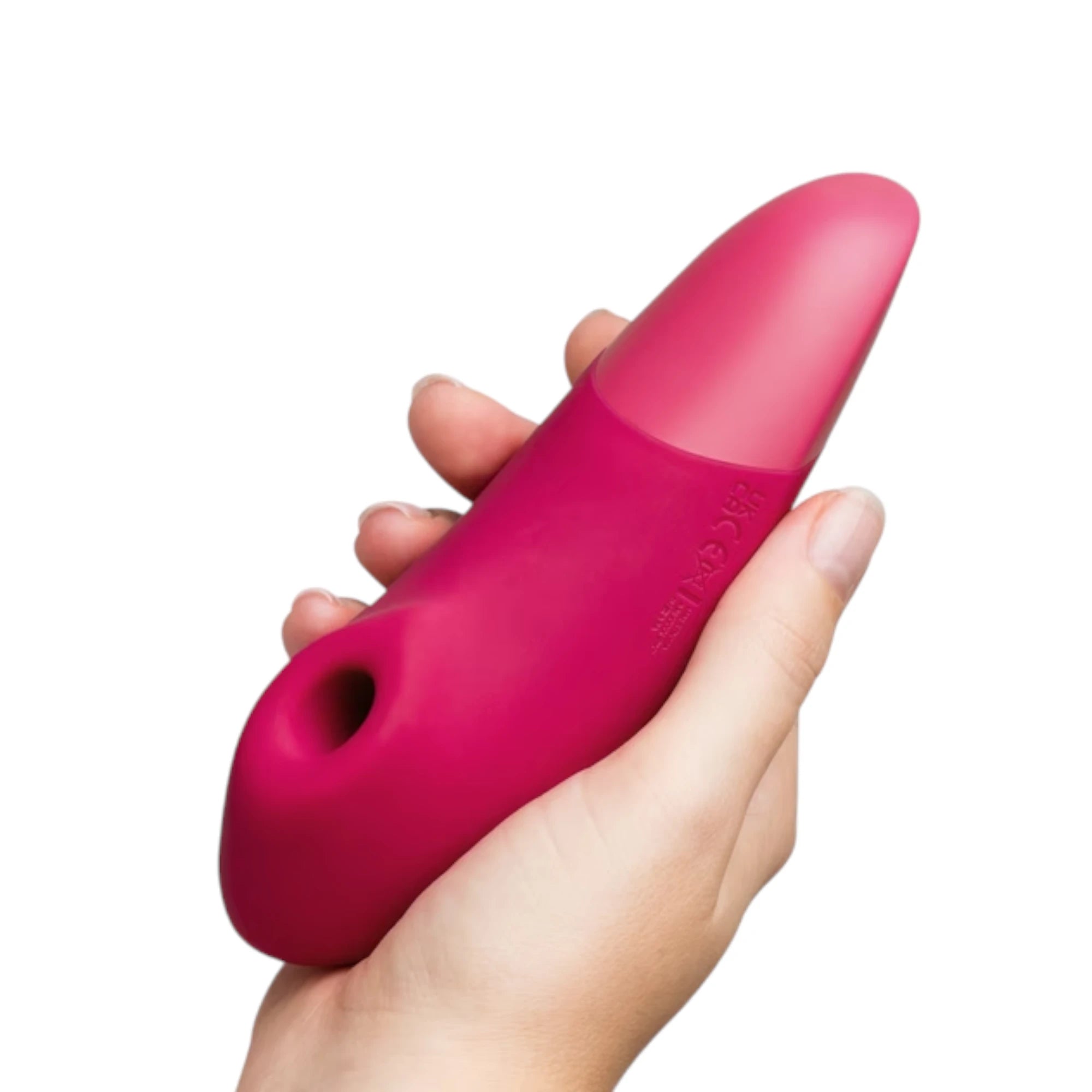 Womanizer Enhance pink Pleasure Air clitoral vibrator shown held in a hand at an angle, highlighting the two-tone pink design, soft silicone finish and the Pleasure Air opening at the front for size reference against a white background