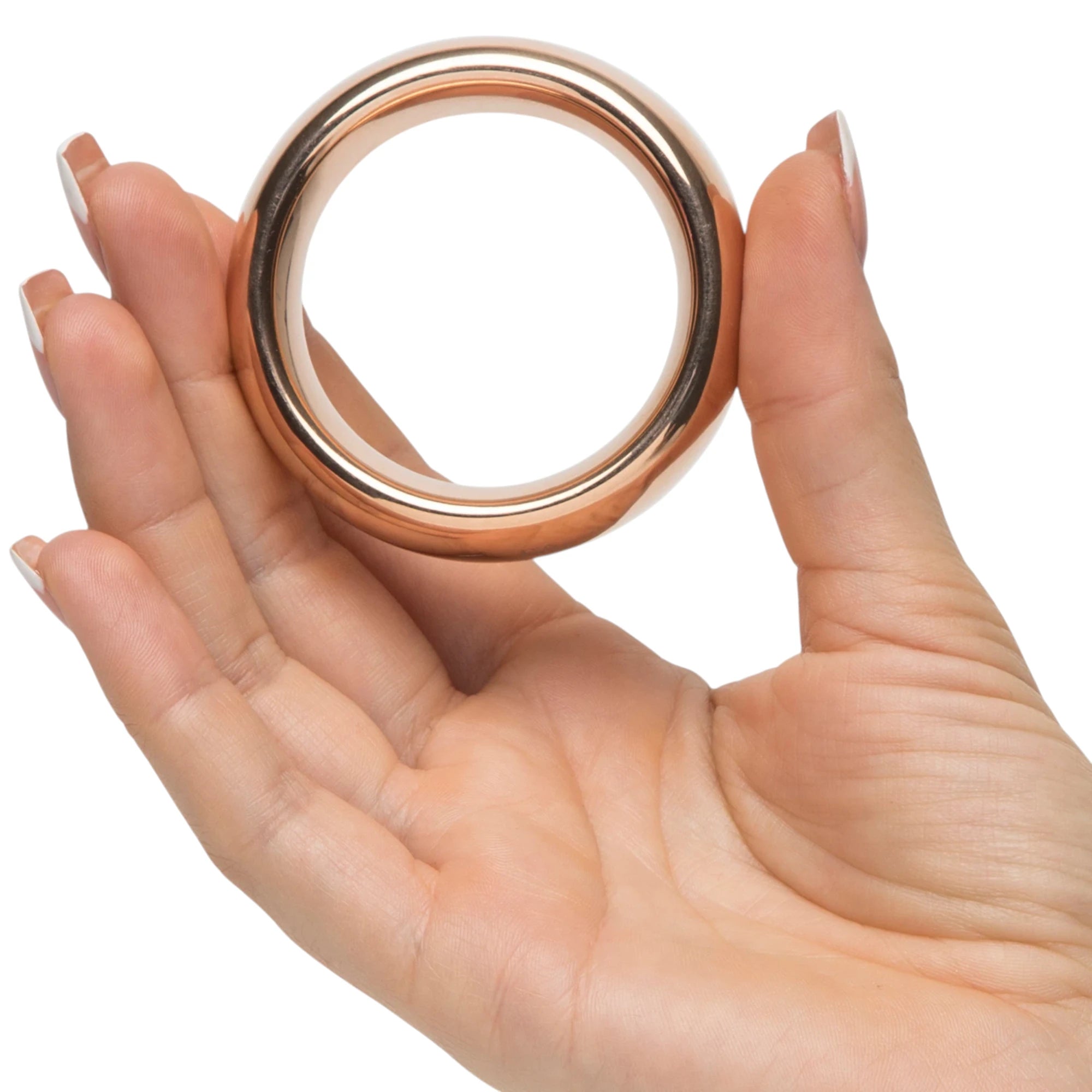 Fifty Shades Freed “I Want You Now” steel love ring in rose-gold finish shown held in a hand for size reference, highlighting the smooth rounded band and wide inner opening against a white background