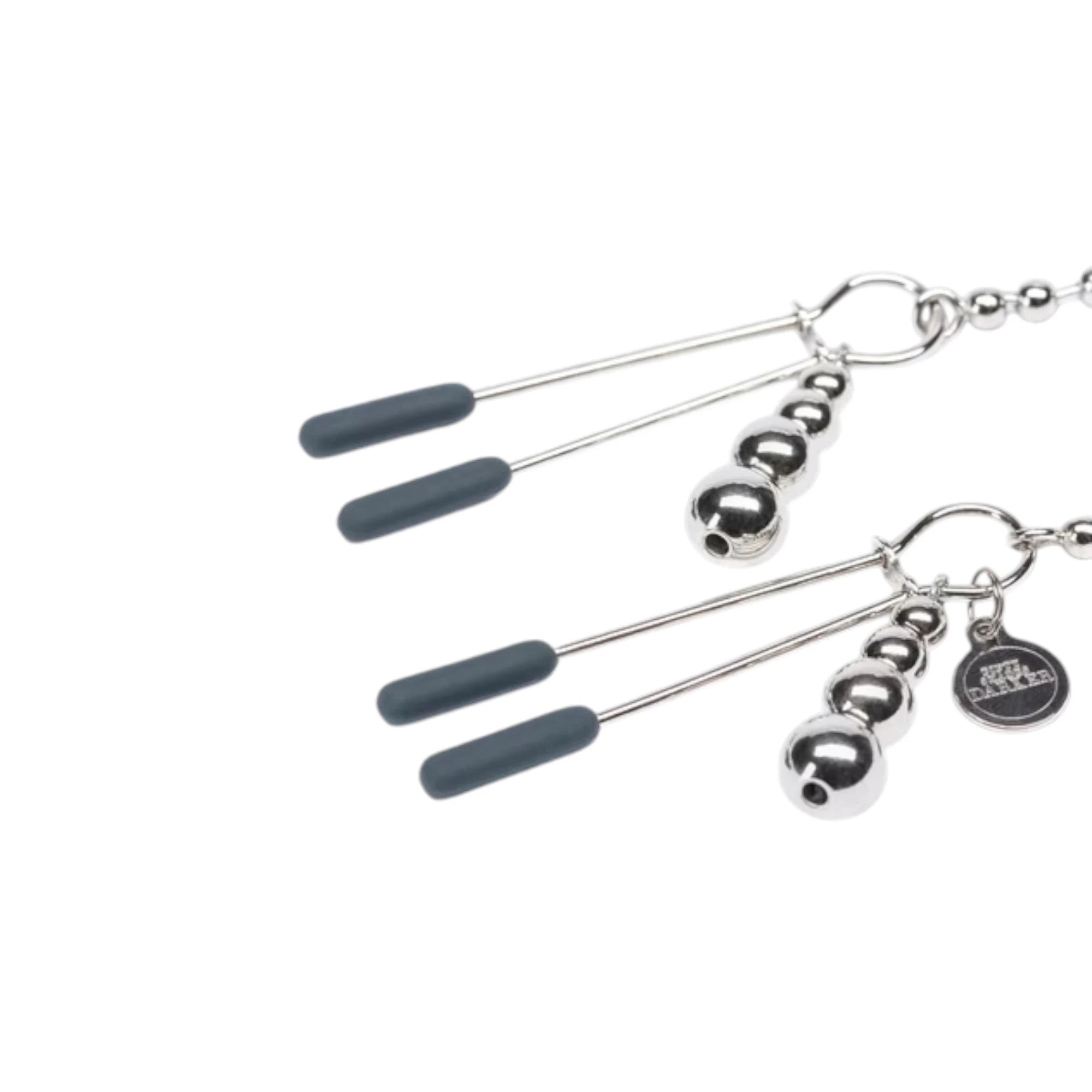 Close-up of the Fifty Shades Darker At My Mercy chained nipple clamps, showing the silver metal clamps with grey rubber tips, beaded chain connector, dangling bead weights and branded charm against a white background