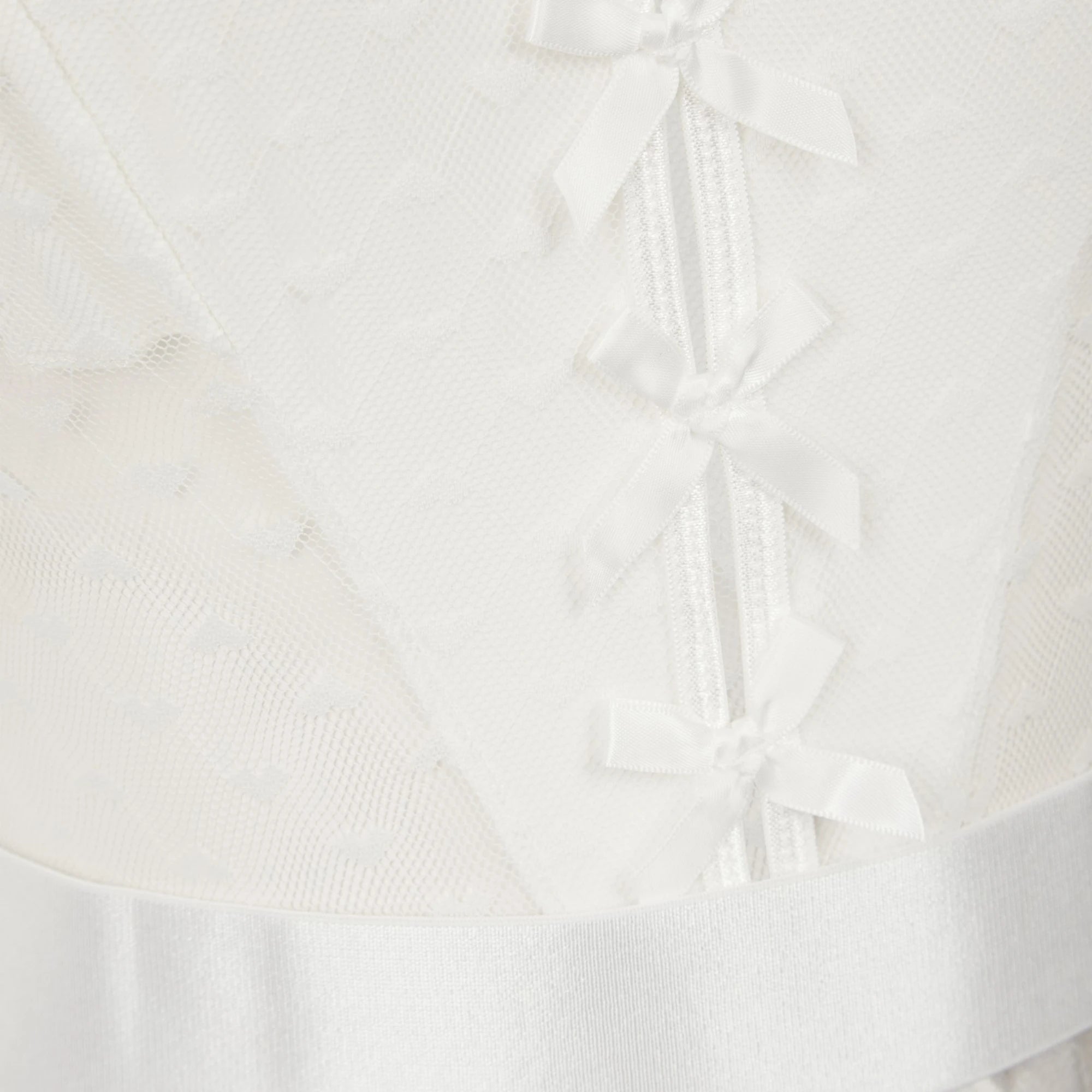 The Lormi Lingerie White Sheer Mesh Bow Front Bodysuit with Suspenders in white with a close-up view of the sheer mesh fabric and bow details down the front, shown on a plain white background