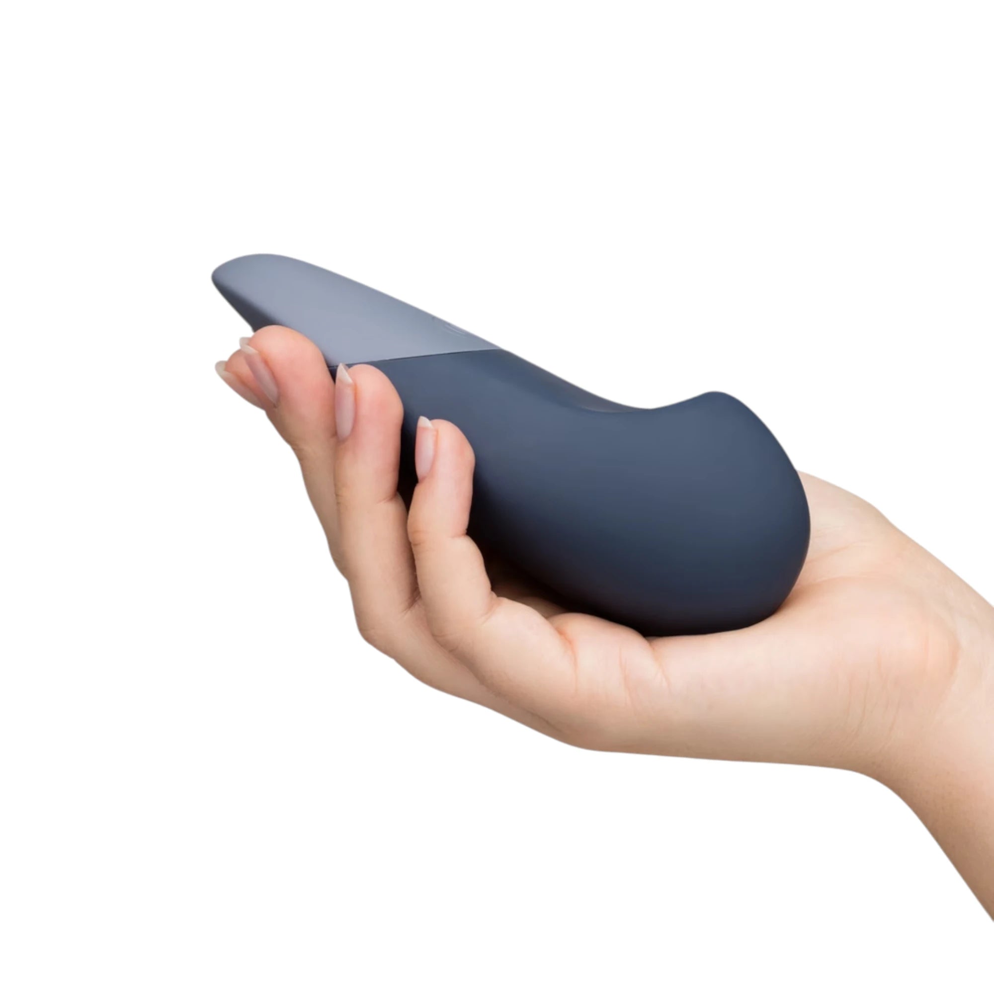Womanizer Vibe blue rechargeable lay-on clitoral vibrator shown resting in a hand for scale, highlighting the compact curved shape, smooth silicone finish and two-tone blue design against a white background