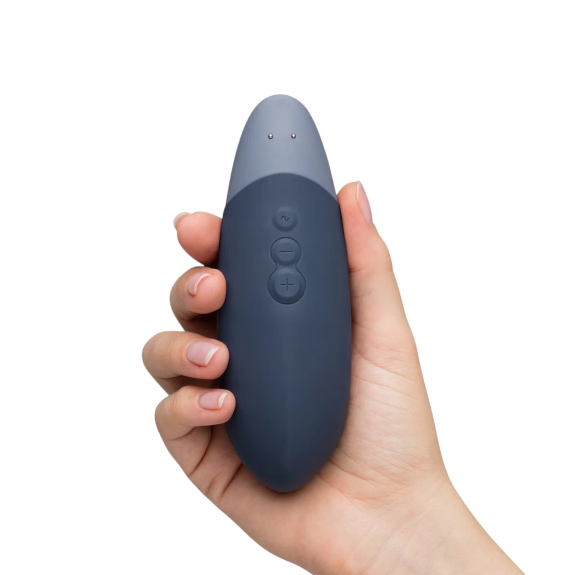Womanizer Vibe blue rechargeable lay-on clitoral vibrator shown held in a hand, with the control buttons visible on the front and the two-tone blue design shown against a white background for size reference