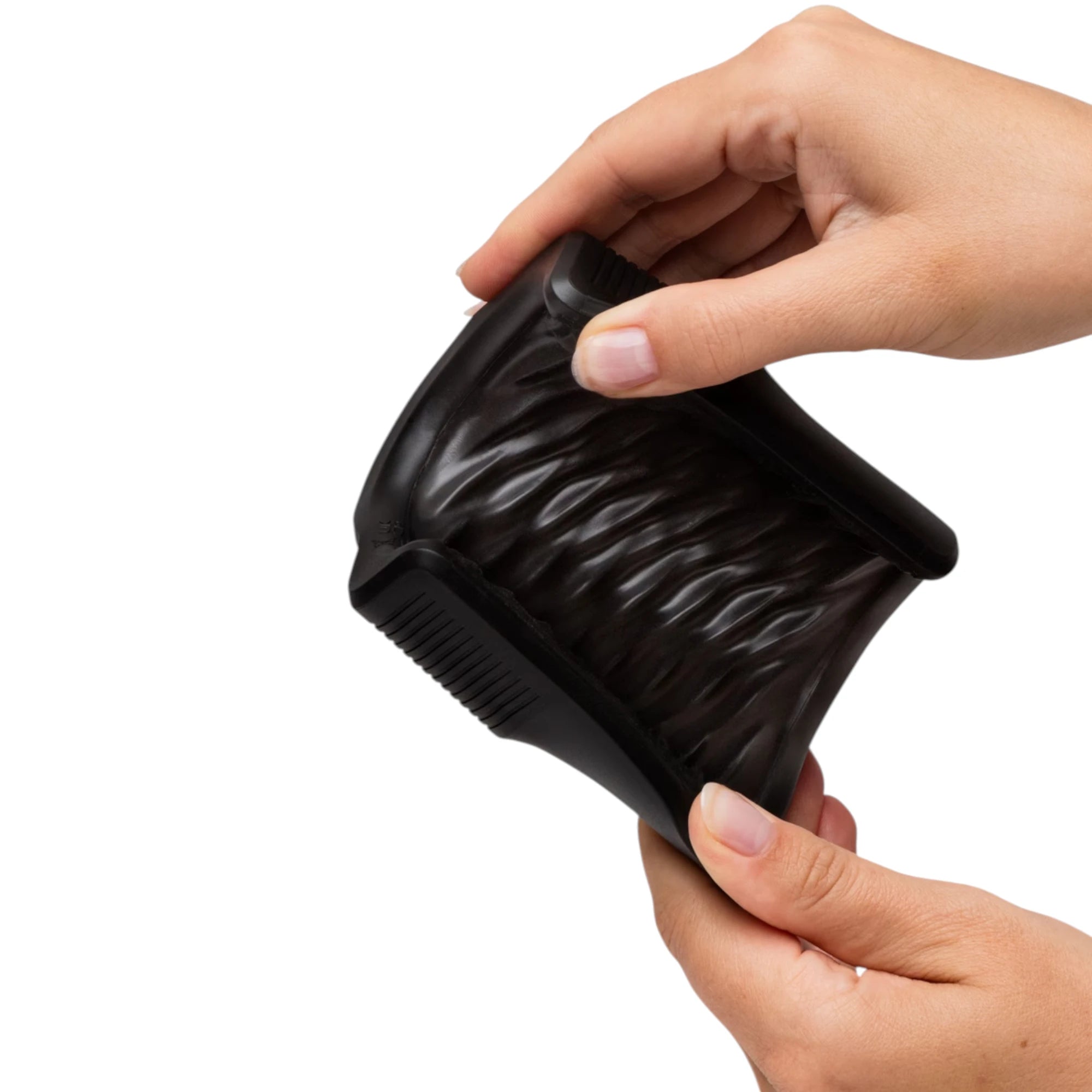 Arcwave Zing black vibrating male masturbator sleeve held in hands showing flexible textured silicone interior insert against white background