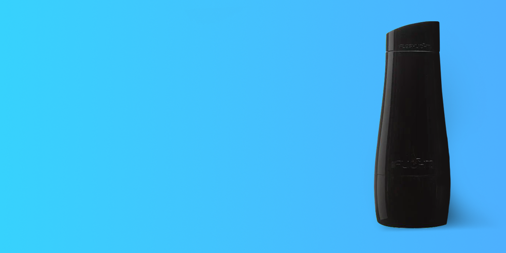 Black cylindrical lubricant bottle with a tapered top and embossed branding text, positioned vertically on the right side of a bright sky-blue background with large empty space on the left