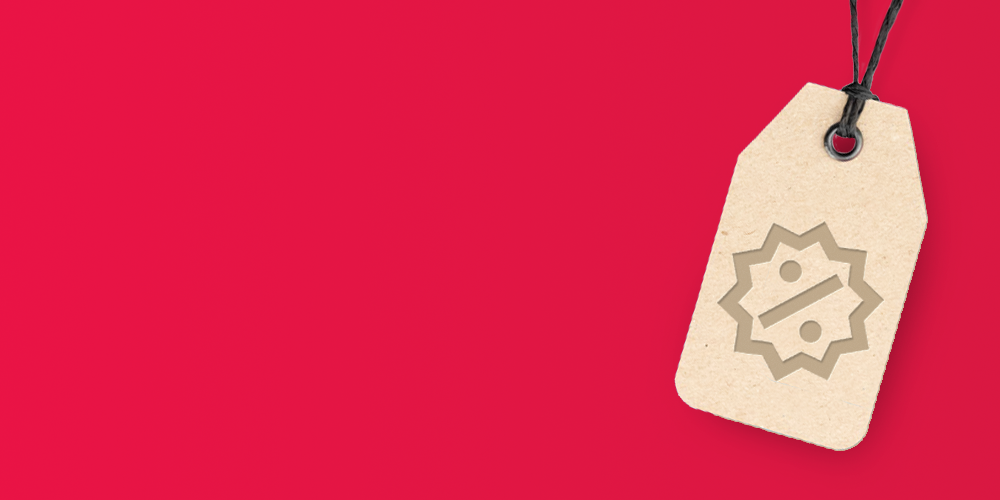 Homepage sale banner with a solid bright red background and a beige paper price tag hanging from a black string in the top-right corner; the tag has a punched hole with a metal eyelet and features a grey discount icon showing a percentage symbol inside a starburst badge