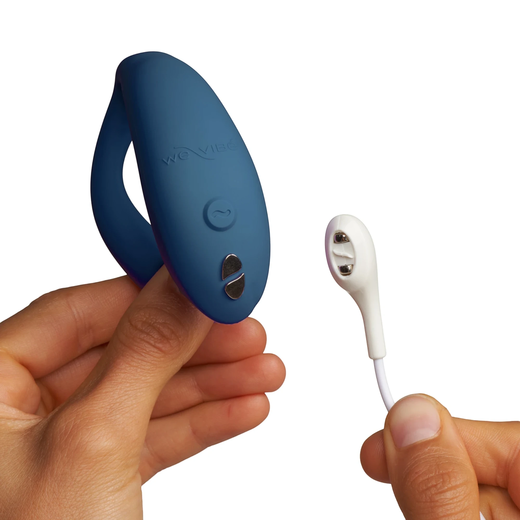 We-Vibe Sync O navy blue couples vibrator with white USB charging cable held in hands against white background