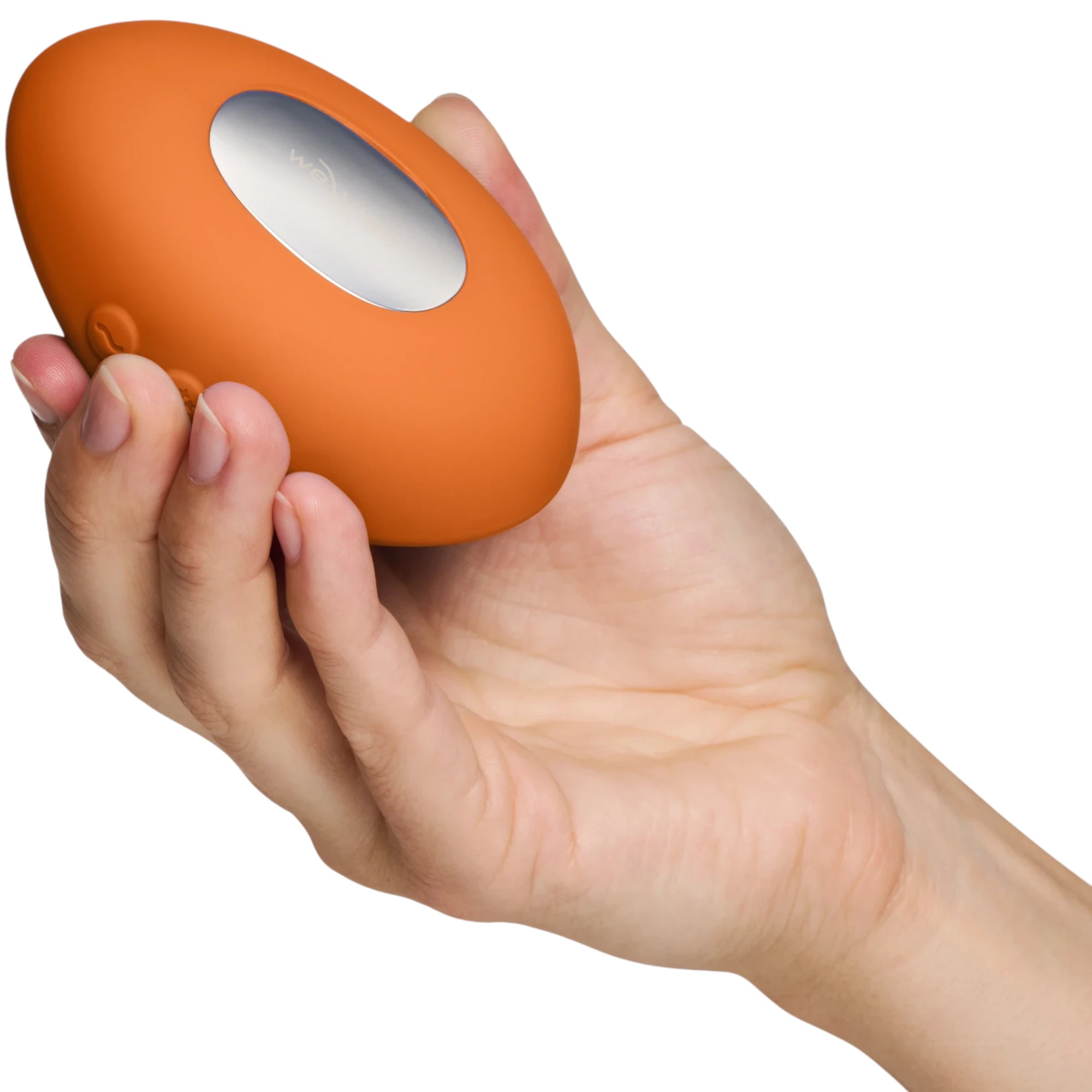We-Vibe Hot+Cold clitoral vibrator in terracotta orange held in hand displaying oval body, We-Vibe branding window, dual motor control buttons, and smooth silicone finish
